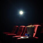 Dark home theater with a glowing projector beam, ready for a superhero movie marathon